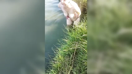 The wife washes herself at the river