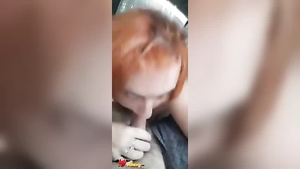 Redhead gives blowjob to her lover in the car