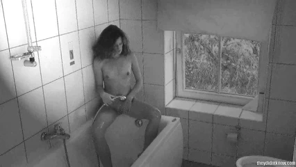 Naked Vera washes herself in the shower with the windows open