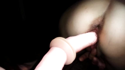 Shoves a rubber dildo into herself