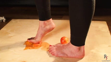 Natalya tramples tomatoes with her bare feet