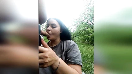 Busty brunette sucks cock outdoors