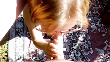 Woman with glasses gives blowjob in nature