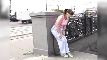 A fat fat girl in wet jeans walks down the street