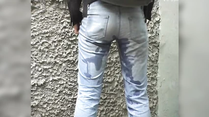 On the street, a brunette pissed in her jeans